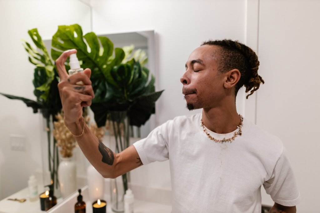 Young Man Applying Spray on Face