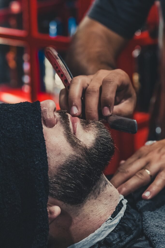 Barber shaving a mans beard