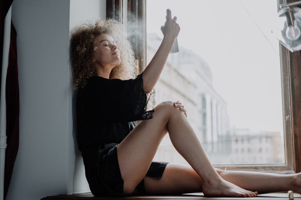 woman in black dress sitting on window