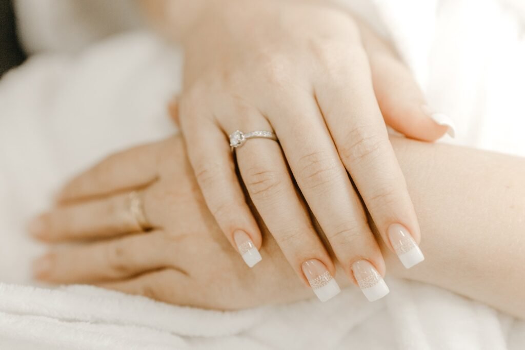 Hands of crop bride with manicure and ring