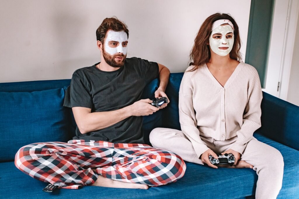 Man and Woman with Facial Cream Sitting on Couch Playing Video Game