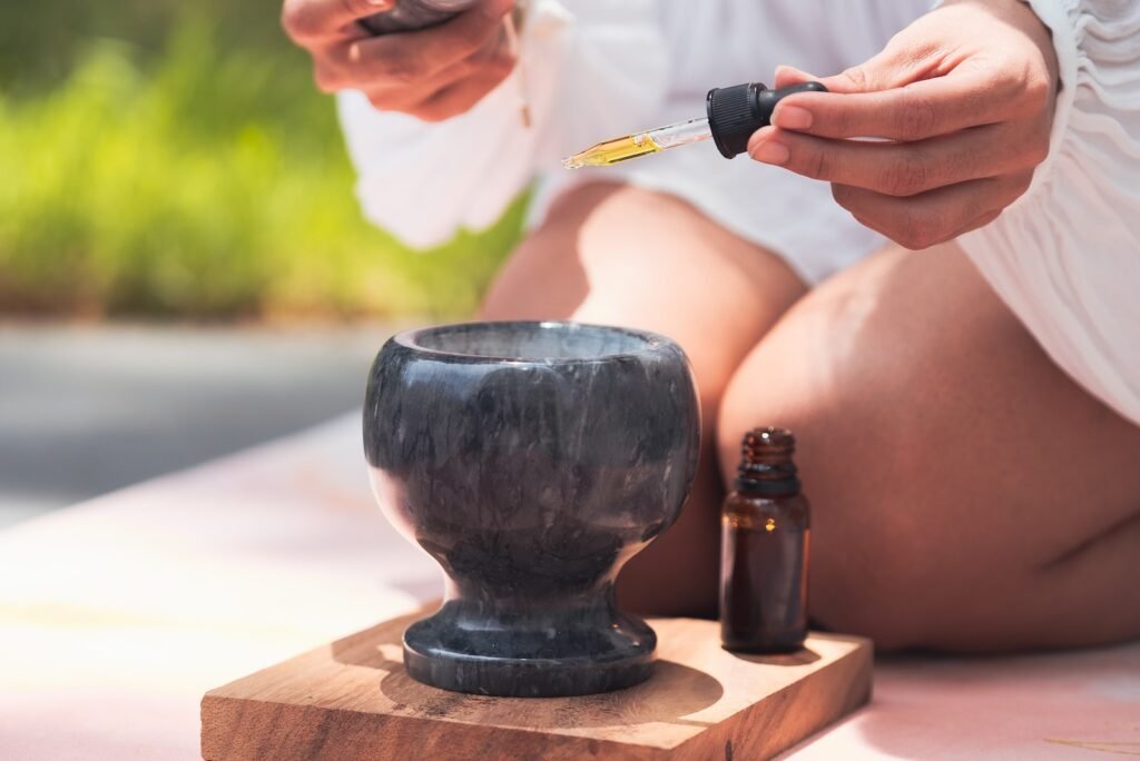 A Hand Putting Oil on Ceramic Bowl