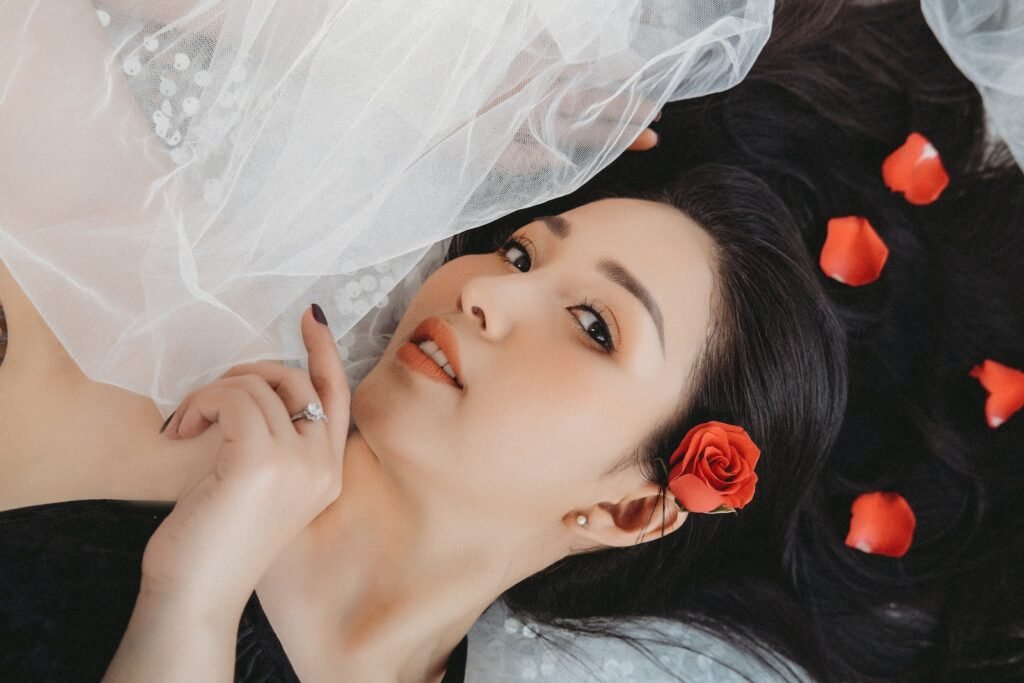 Romantic Asian woman lying on white tulle fabric