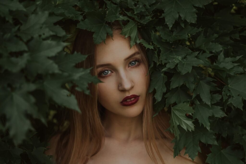 Dreamy young lady standing under tree branches